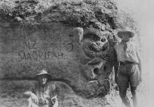 A maori tiki carved into the rock along the main sap to Fisherman's hut. The sign reads : NZ Maori pah and a carved hand pointing to the left indicating the Maori meeting place is to the left. 1915